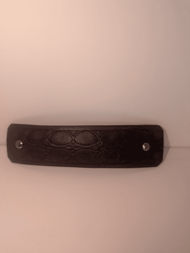 Barrette à cheveux en cuir embossé.