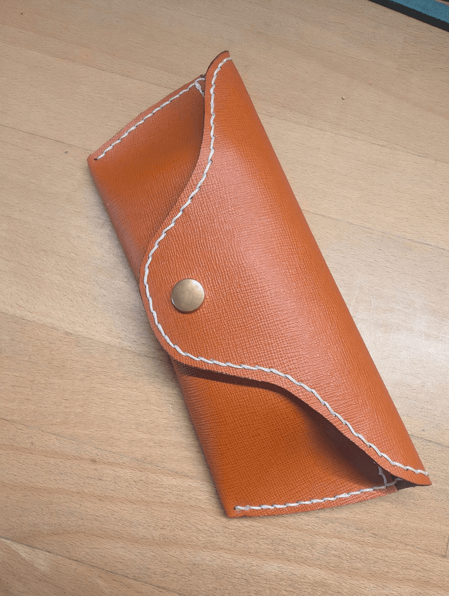 Etui à lunette en cuir orange.